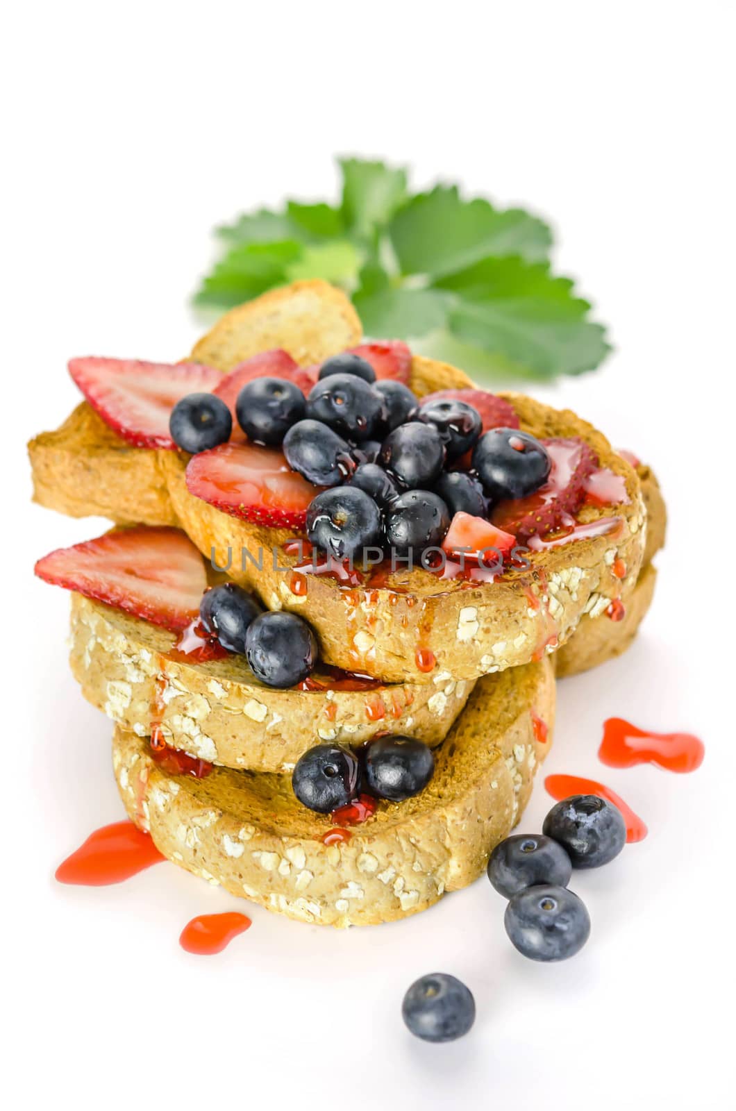 Whole wheat bread with strawberry sauce and fresh berries on white background