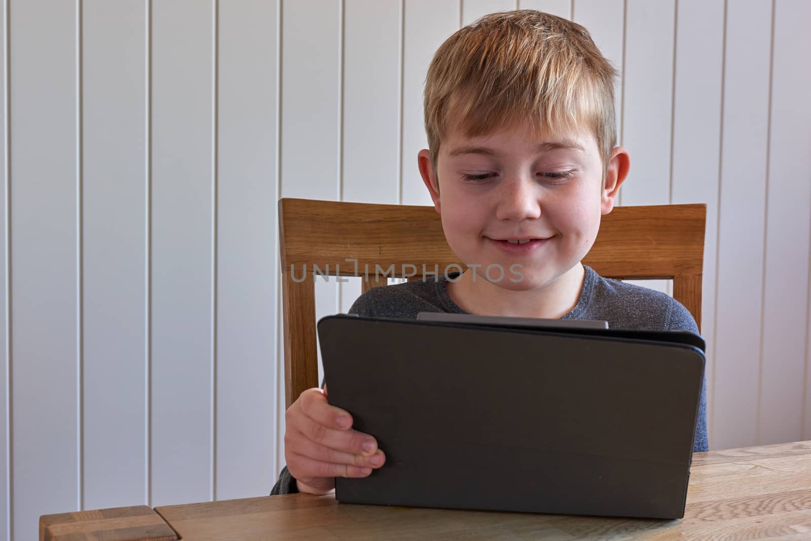 Smiling boy with electronic tablet device.