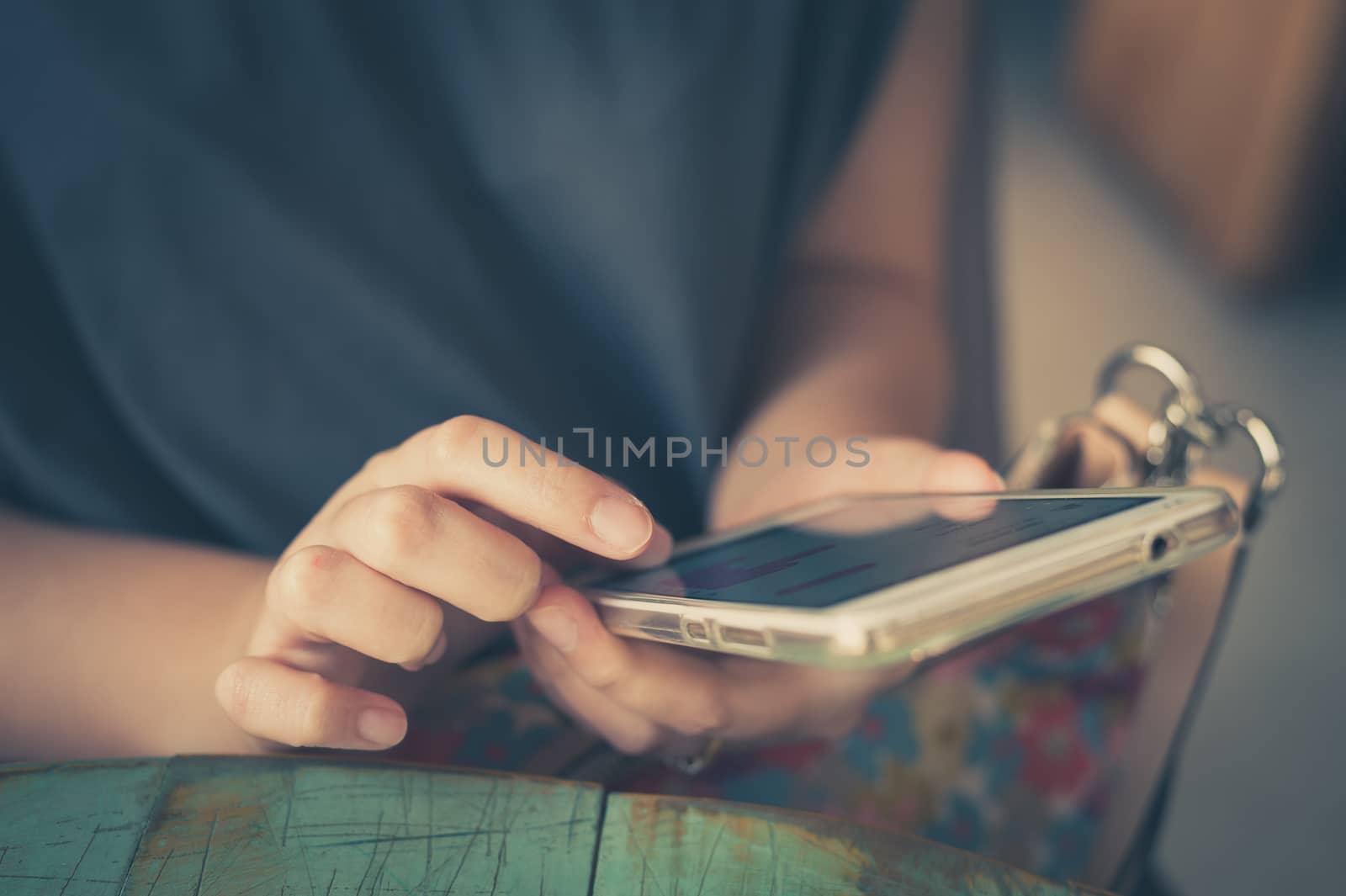 Afternoon scene of young woman using smartphone for social networking in cafe on weekend. Weekend modern lifestyle with technology concept. processed with vintage filter effect