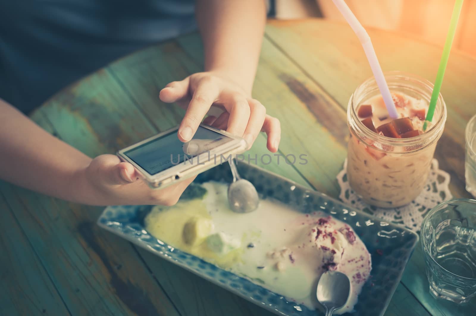 Afternoon scene of young woman using smartphone for social networking in cafe on weekend. Trendy lifestyle concept with technology. processed with vintage filter effect
