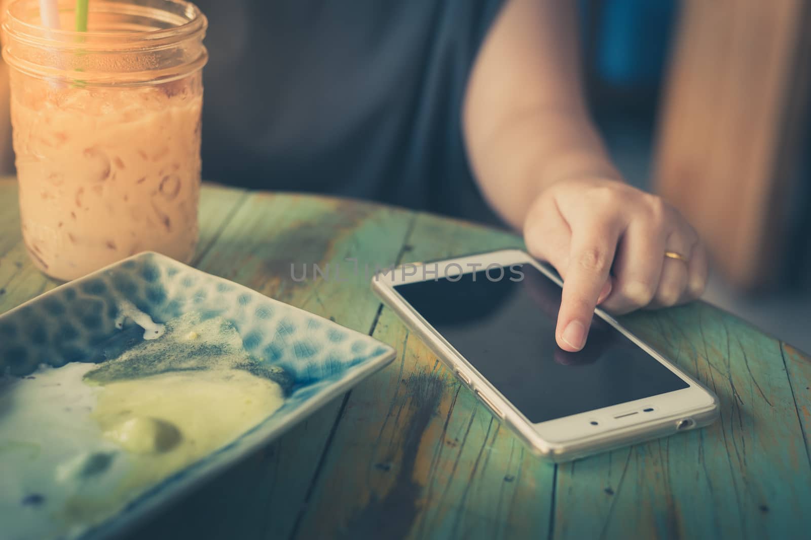 Woman using smartphone in cafe by silatip