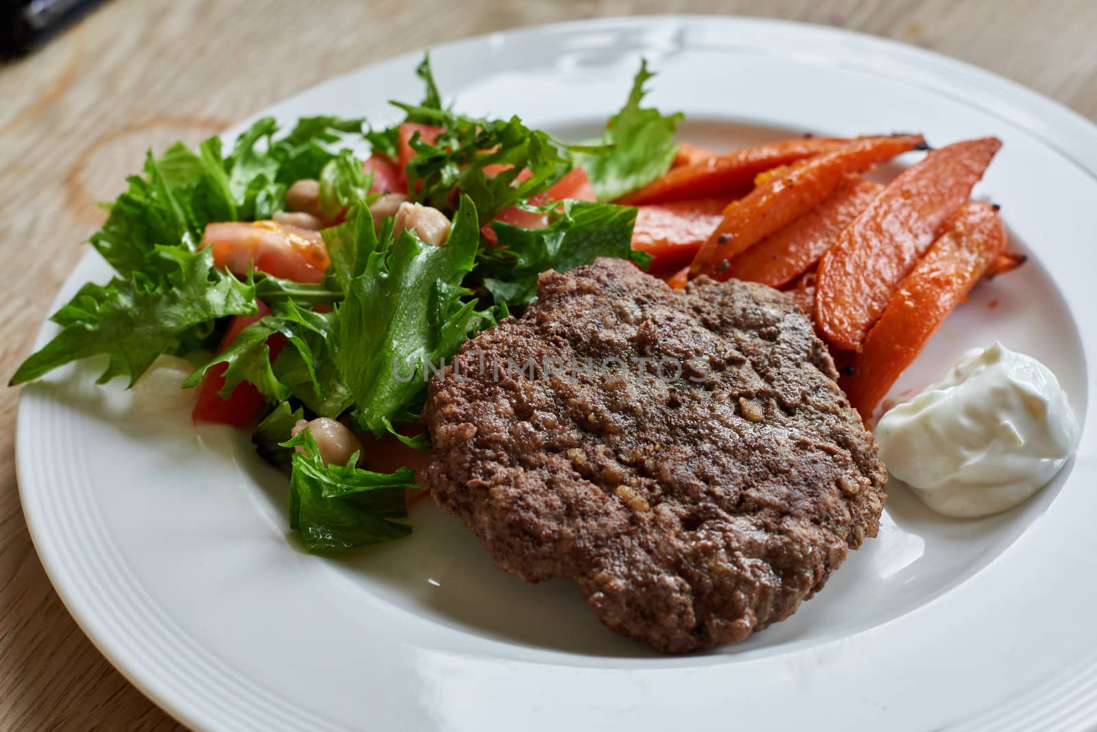 Healthy hamburger with sweet potatoes and fresh salad.