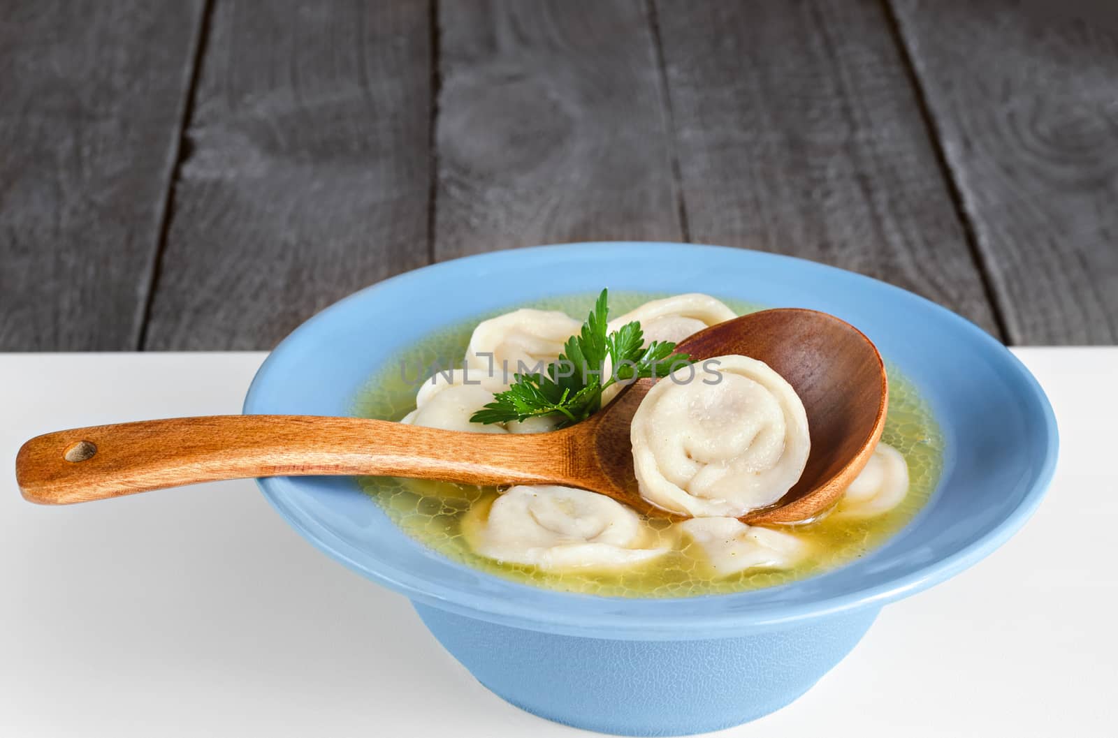 Dumplings in a bowl and wooden spoon by Gaina