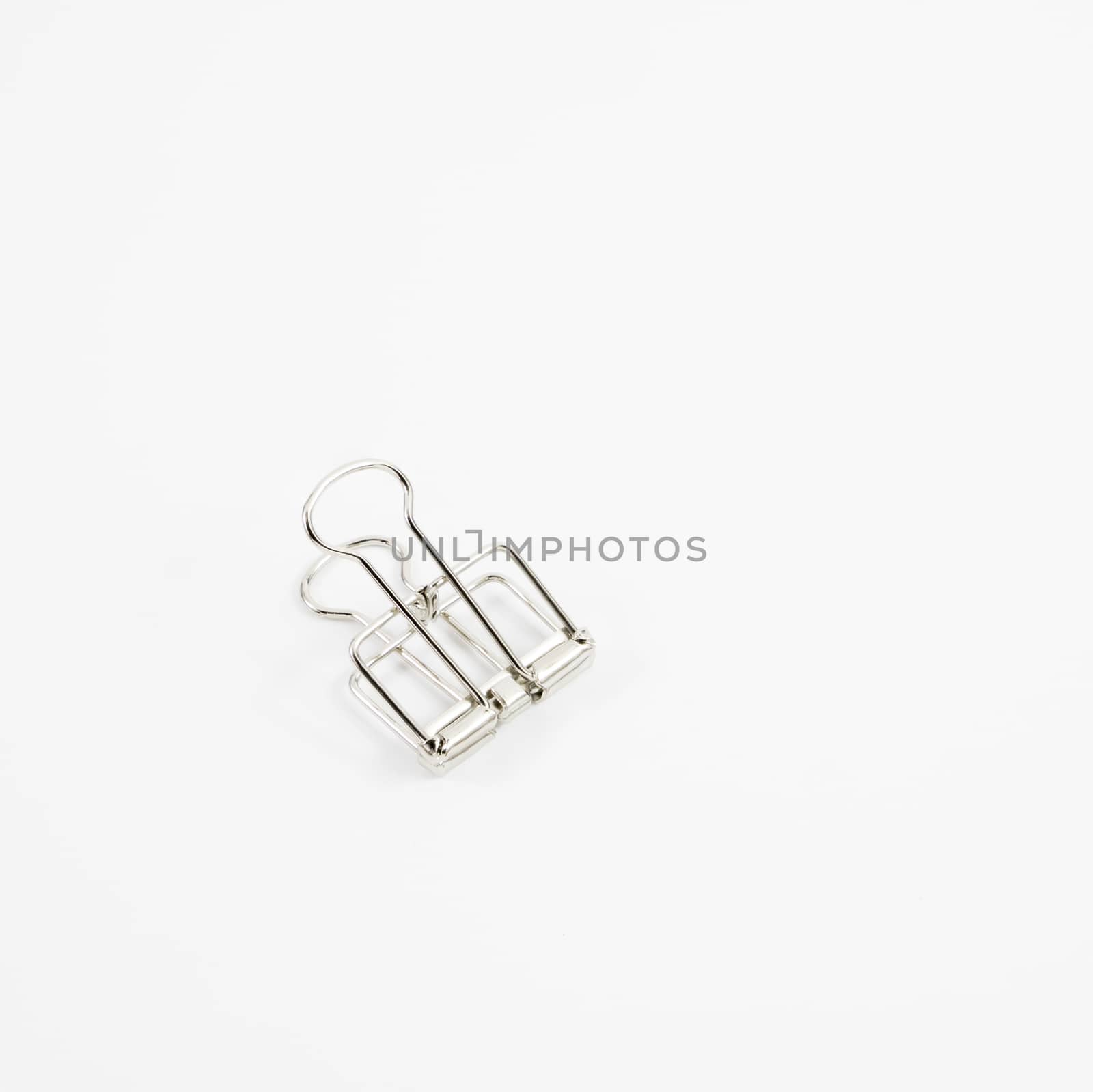 The silver binder clip (paper clip stationery).