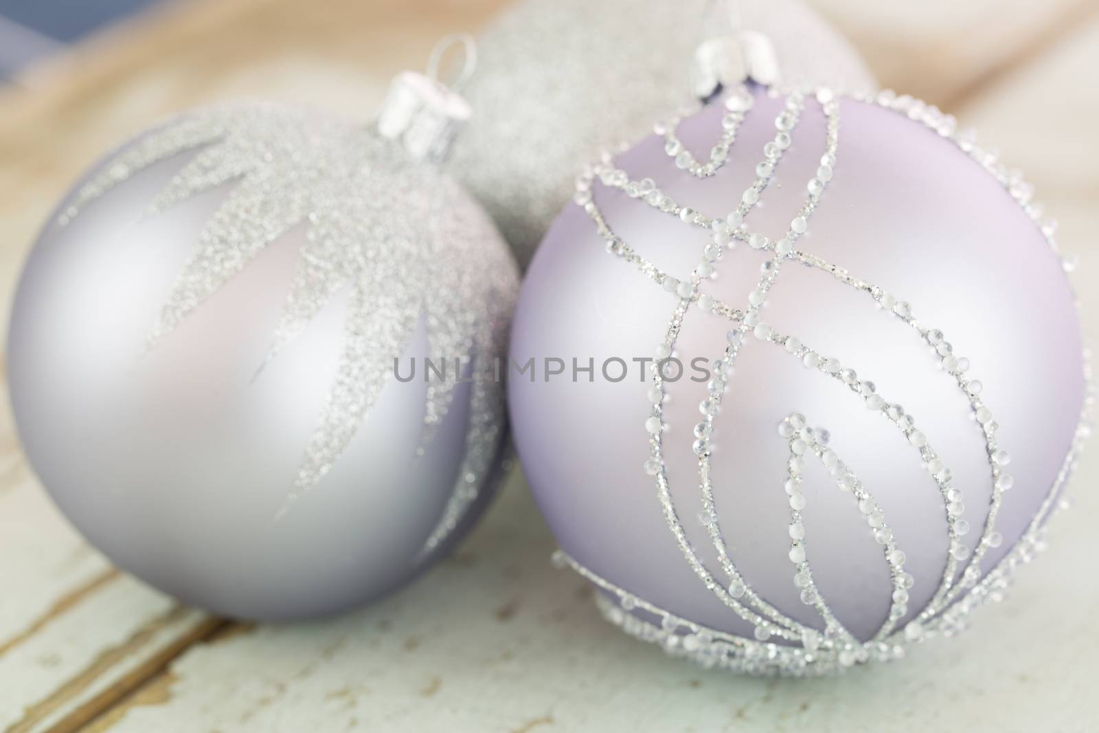 Decorated silver Christmas baubles with focus to a single bauble in the foreground to celebrate Xmas and the festive holiday season