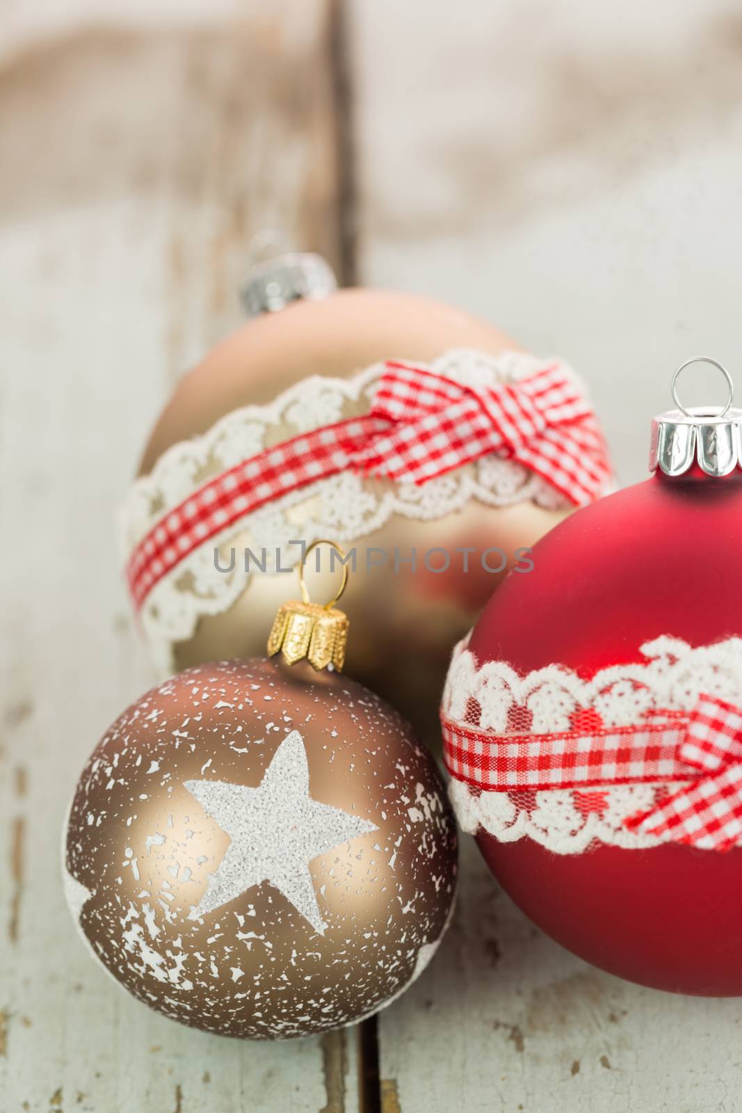Three Christmas baubles on rustic wood by juniart