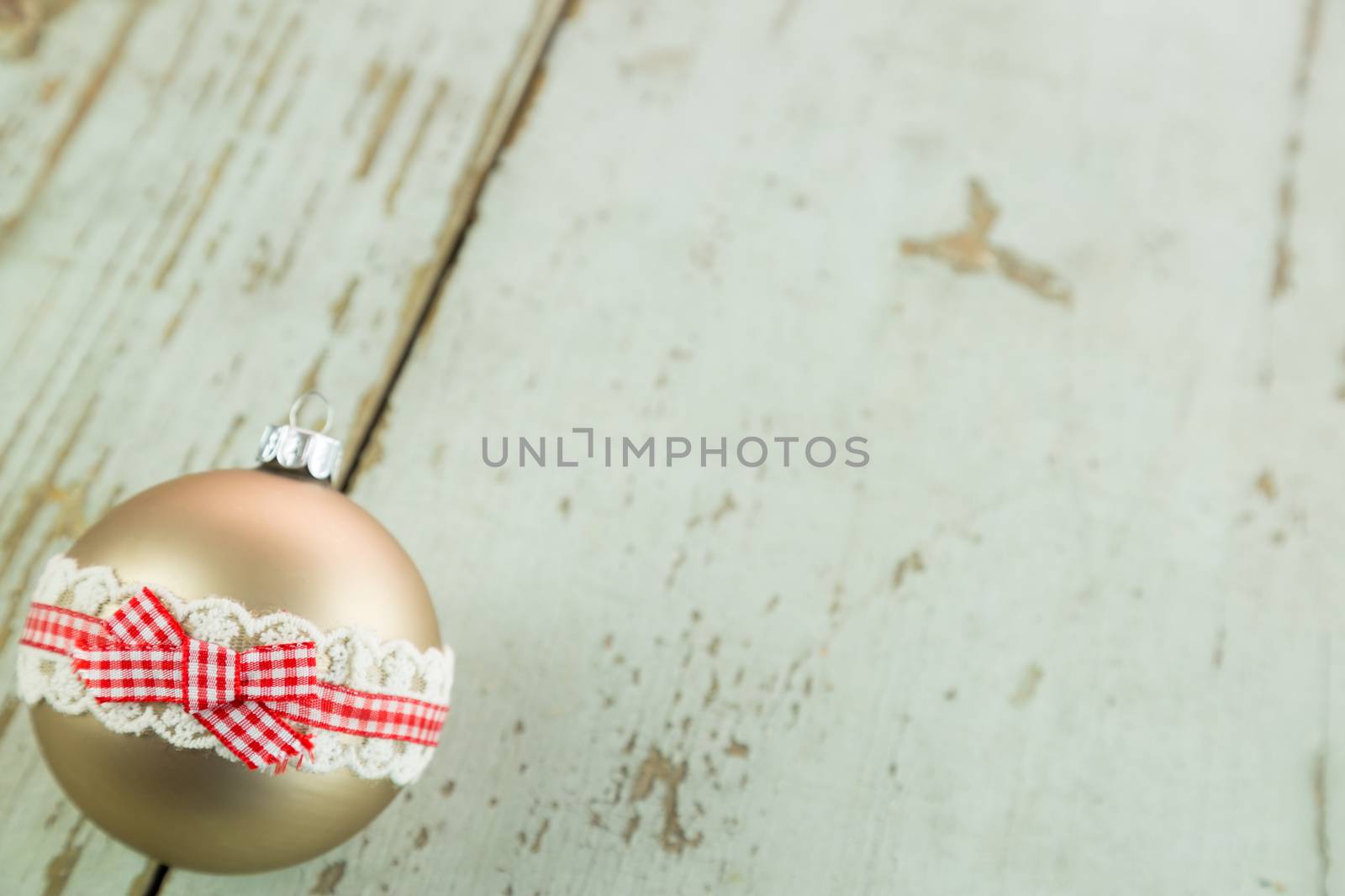 Three colorful decorated Christmas baubles on rustic wood with copy space to celebrate the Xmas holiday season