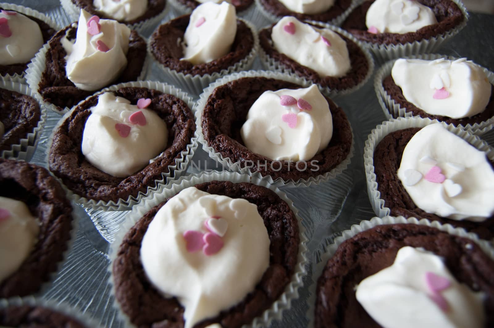 Brownie cupcakes with whipped cream and heart decorations