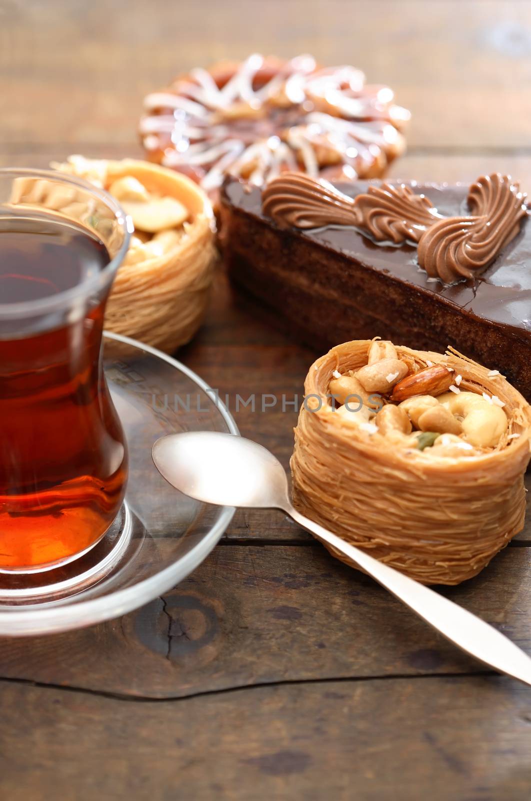 Set of various cakes near tea on nice wooden background