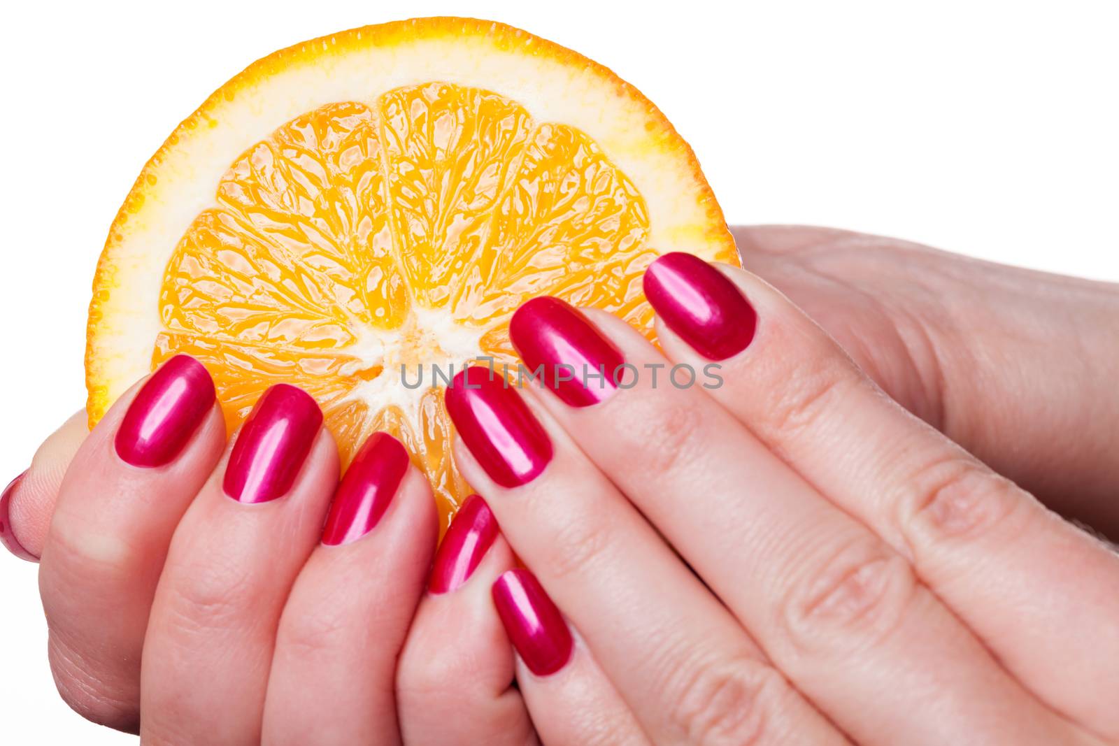 Hand with manicured nails painted a deep glossy red touch an orange on white background