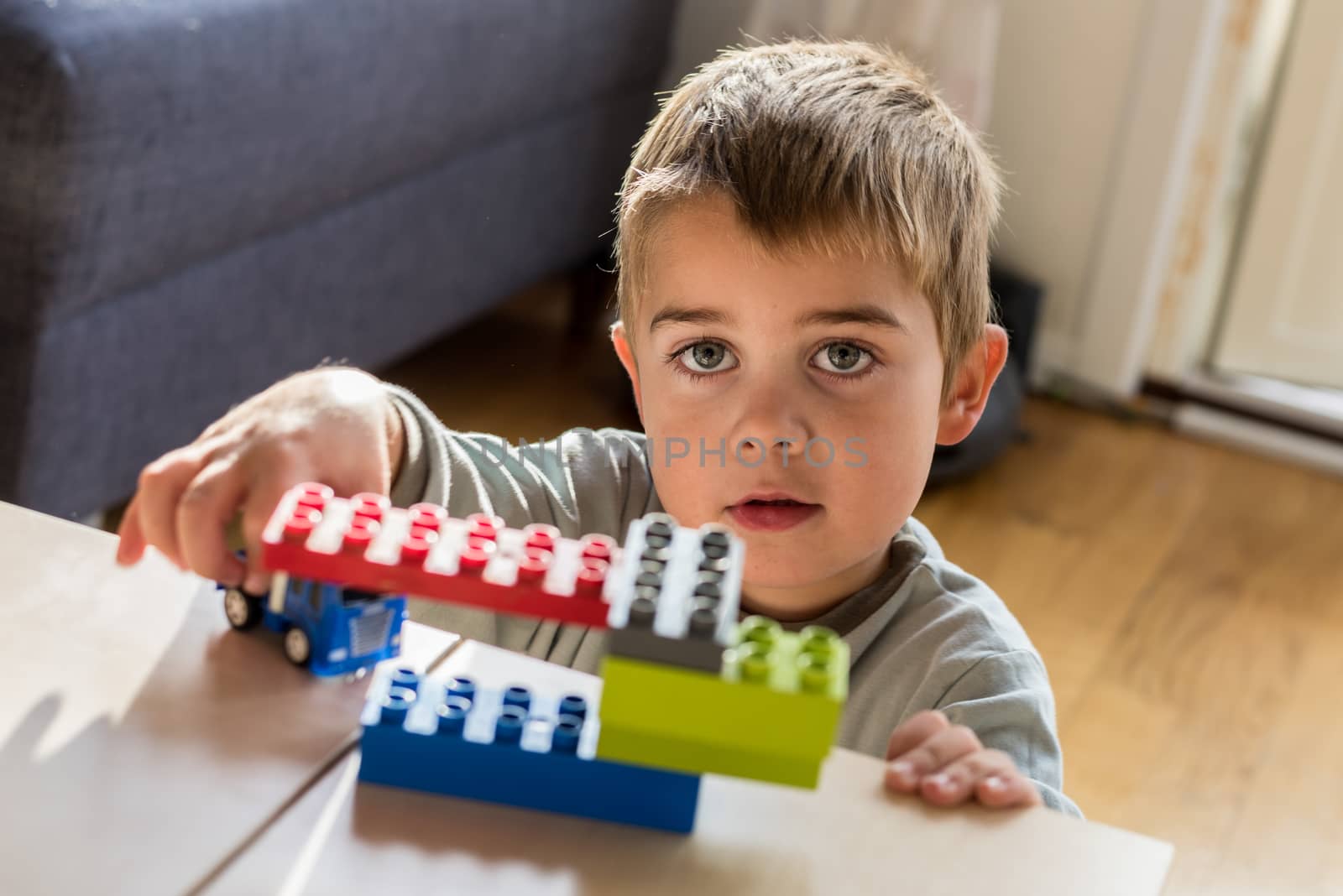 Happy boy playing with his toys.