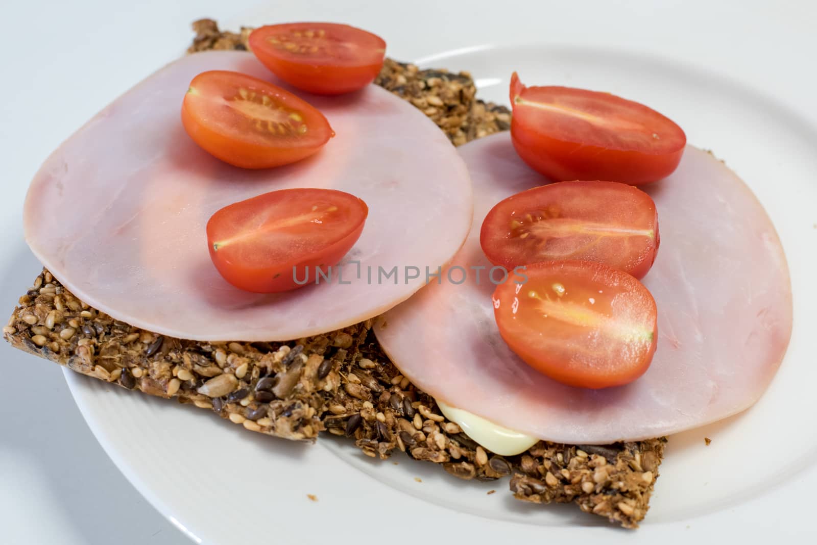 Crispy bread made from seeds, with tomatoes, ham and mayonnaise