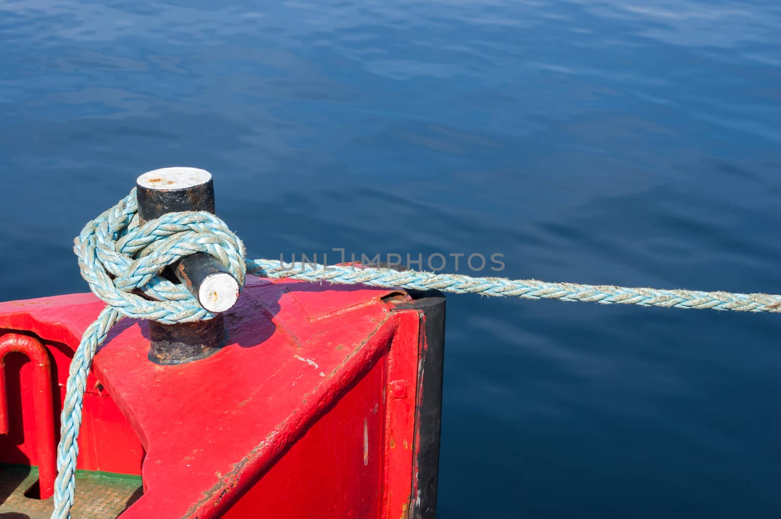 Tight ship cable bound over a mooring bollard.