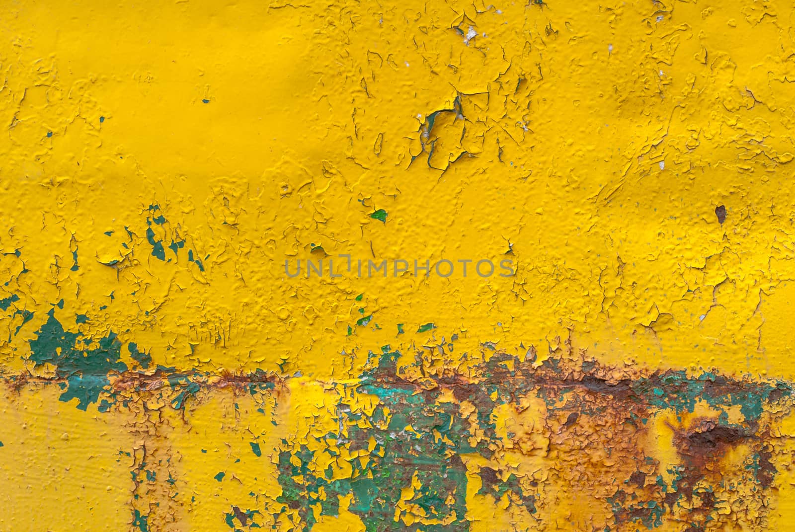 rusty iron surface covered with old chipped yellow color paint, which has long been influenced by different climatic conditions