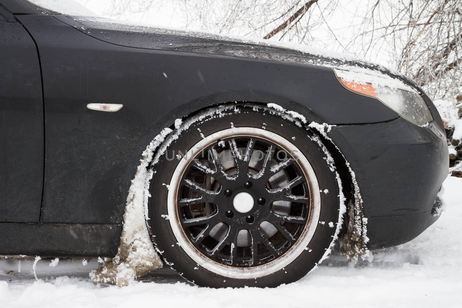 Car covered with snow on the wheels. 
