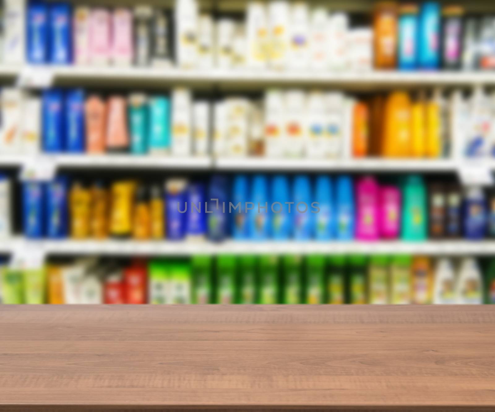 Wooden board empty table in front of blurred background. Perspective brown wood board over blurred colorful supermarket products on shelvest - mock up for display of product.