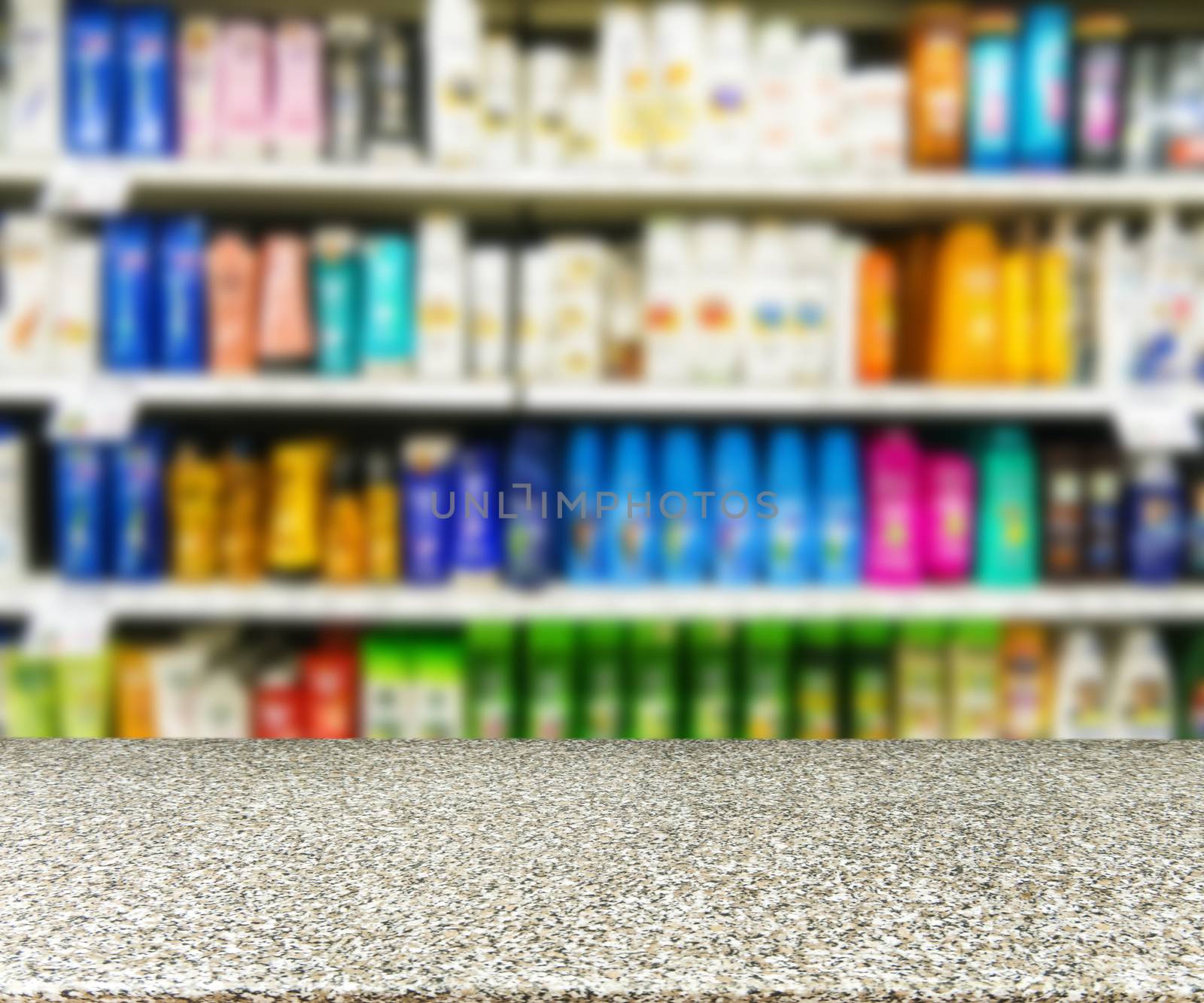 Marble board empty table in front of blurred background. Perspective marble table over blurred colorful supermarket products on shelvest - mock up for display of product.