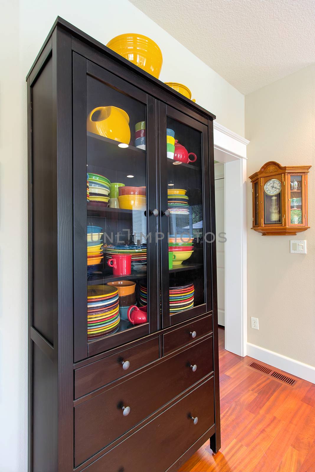 Wood China Cupboard with colorful dinnerware and Oak Pendulum Clock interior home