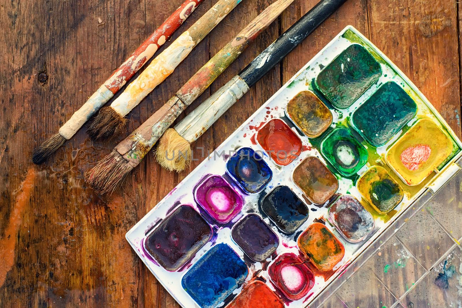 Set of watercolors and different brushes for painting on wood vintage palette