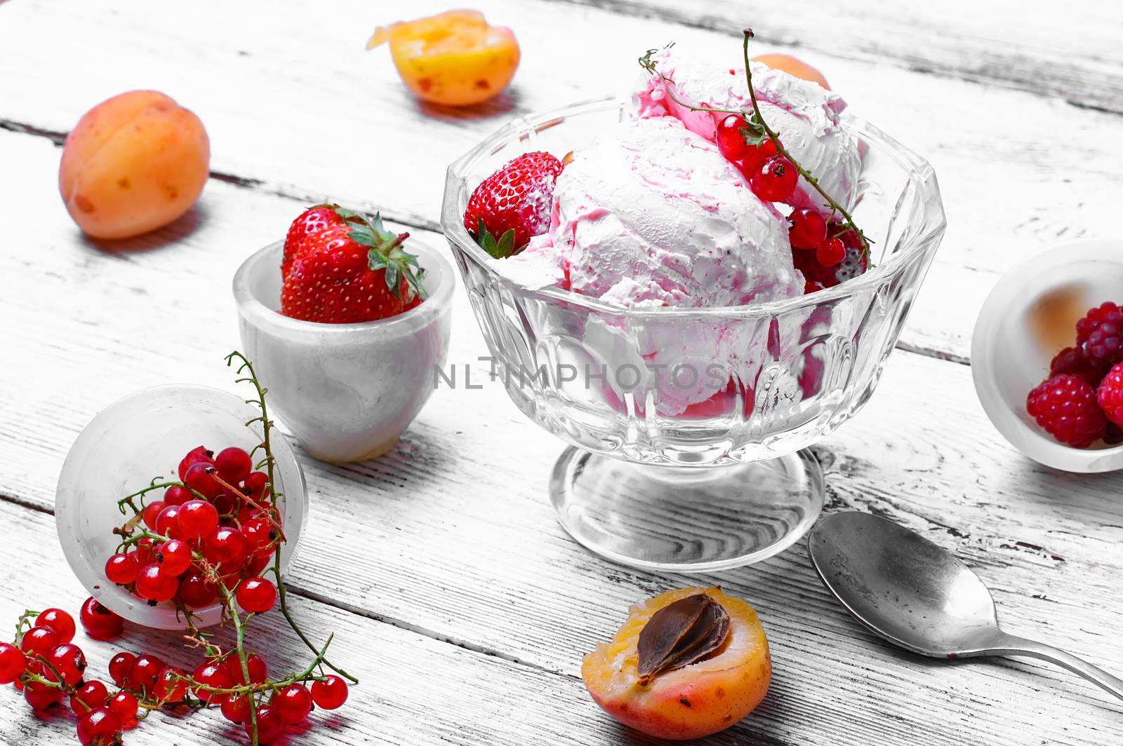 Ice cream with strawberries and currants on light background.Photo in high key