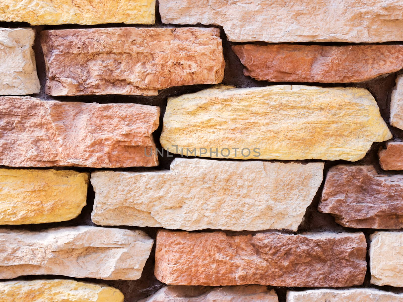 a wall from an artificial gray stone facade with rough fractured surfaces