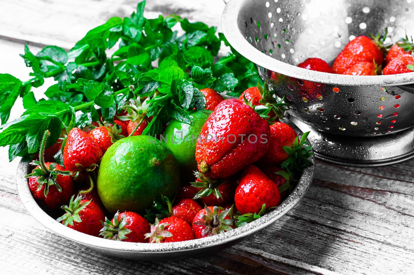Dish with ripe large strawberries,lime and peppermint leaves