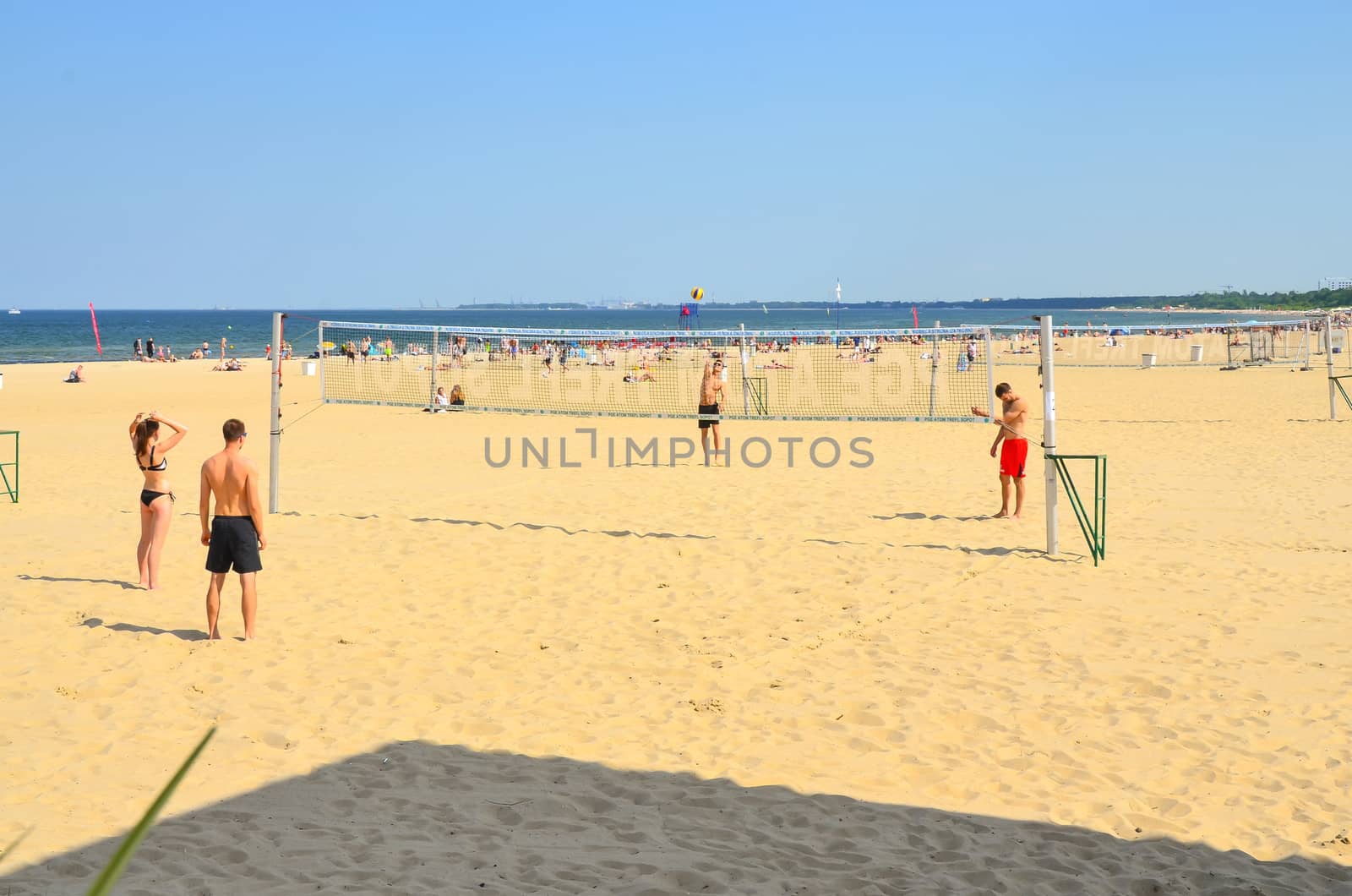 Sopot-Poland June-2016  Group young friends playing volleyball on beach against Baltic sea.