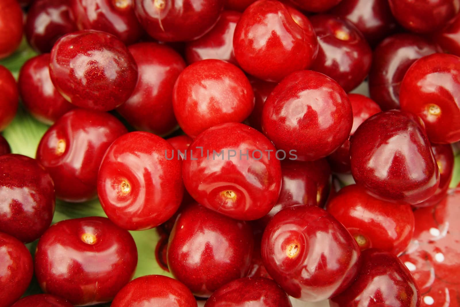 a lot of red cherries on dish, macro background