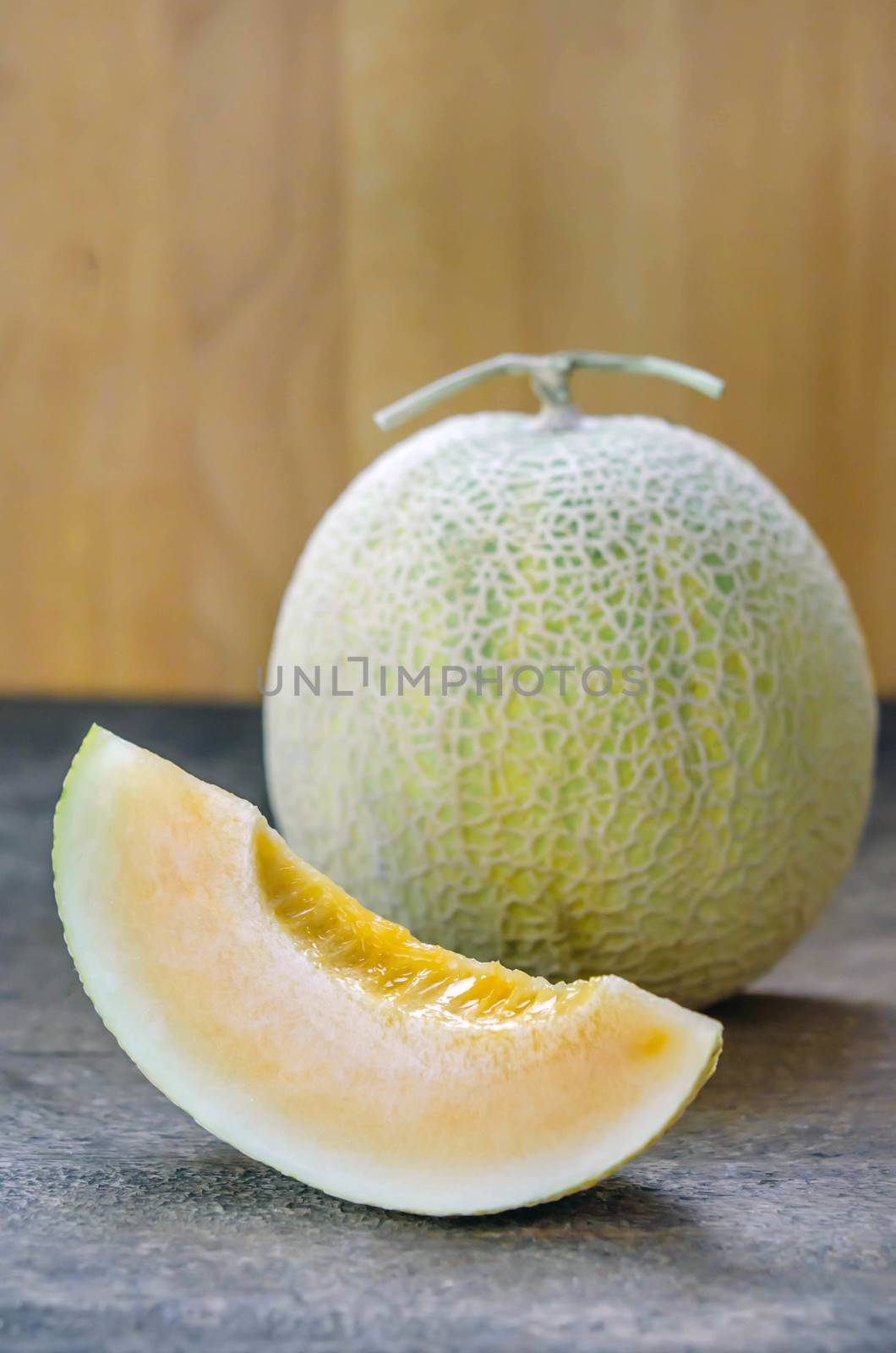 Ripe cantaloupe melon fruit on wooden background
