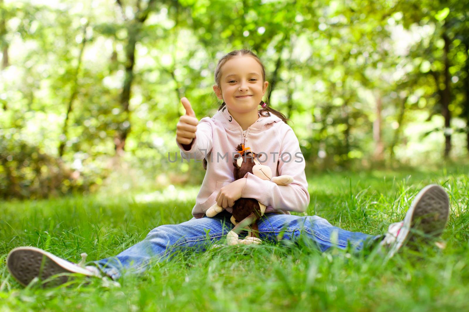 Girl sitting on green grass on a sunny day