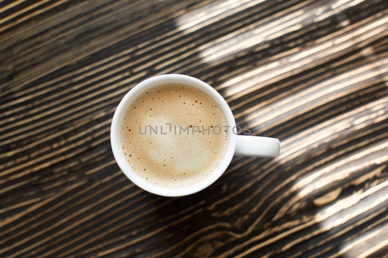 White cup with a coffee drink is on the table