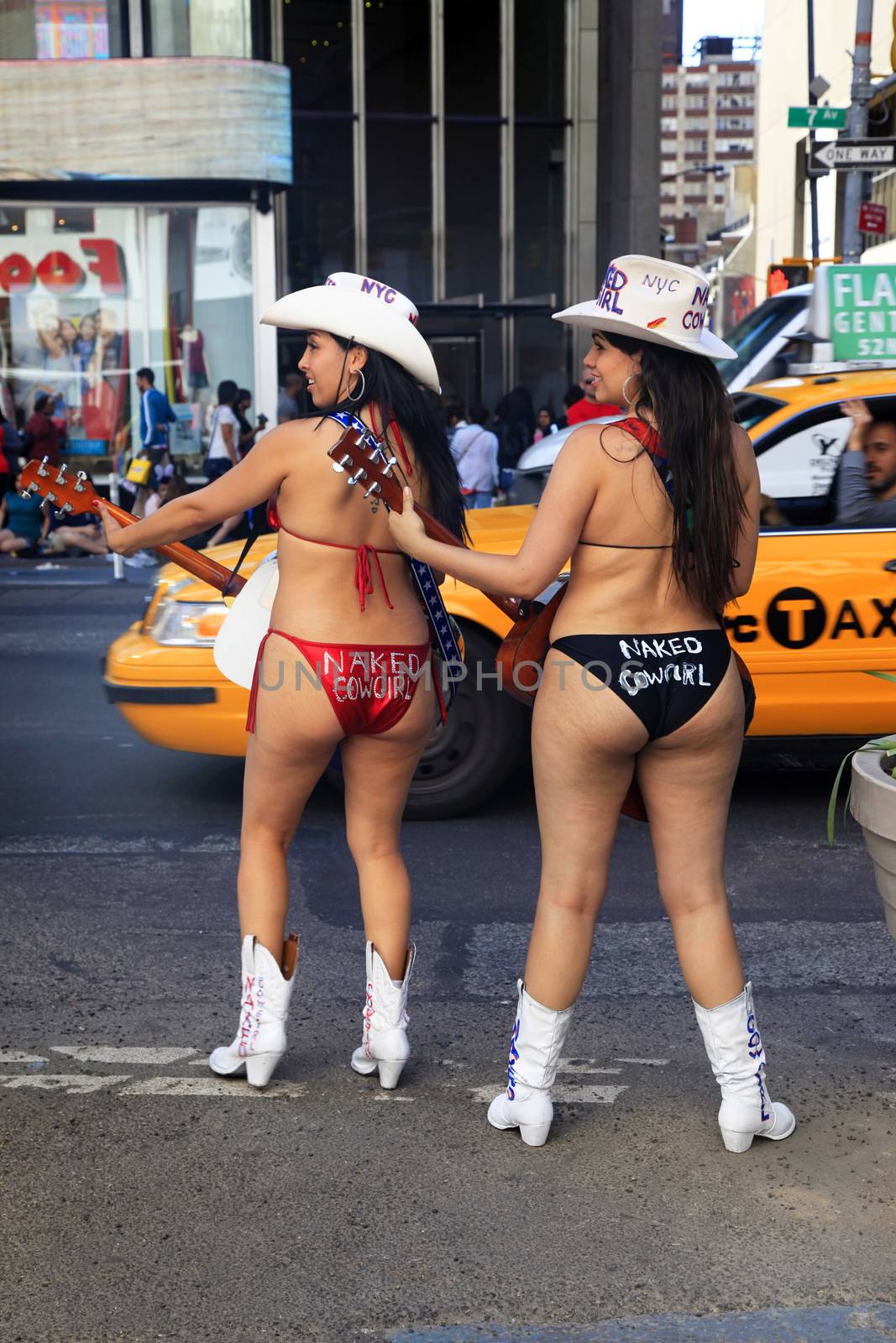 New York City, USA - May 17, 2013: New York City, two naked cowgirls in bikini play guitar on times square manhattan new york city