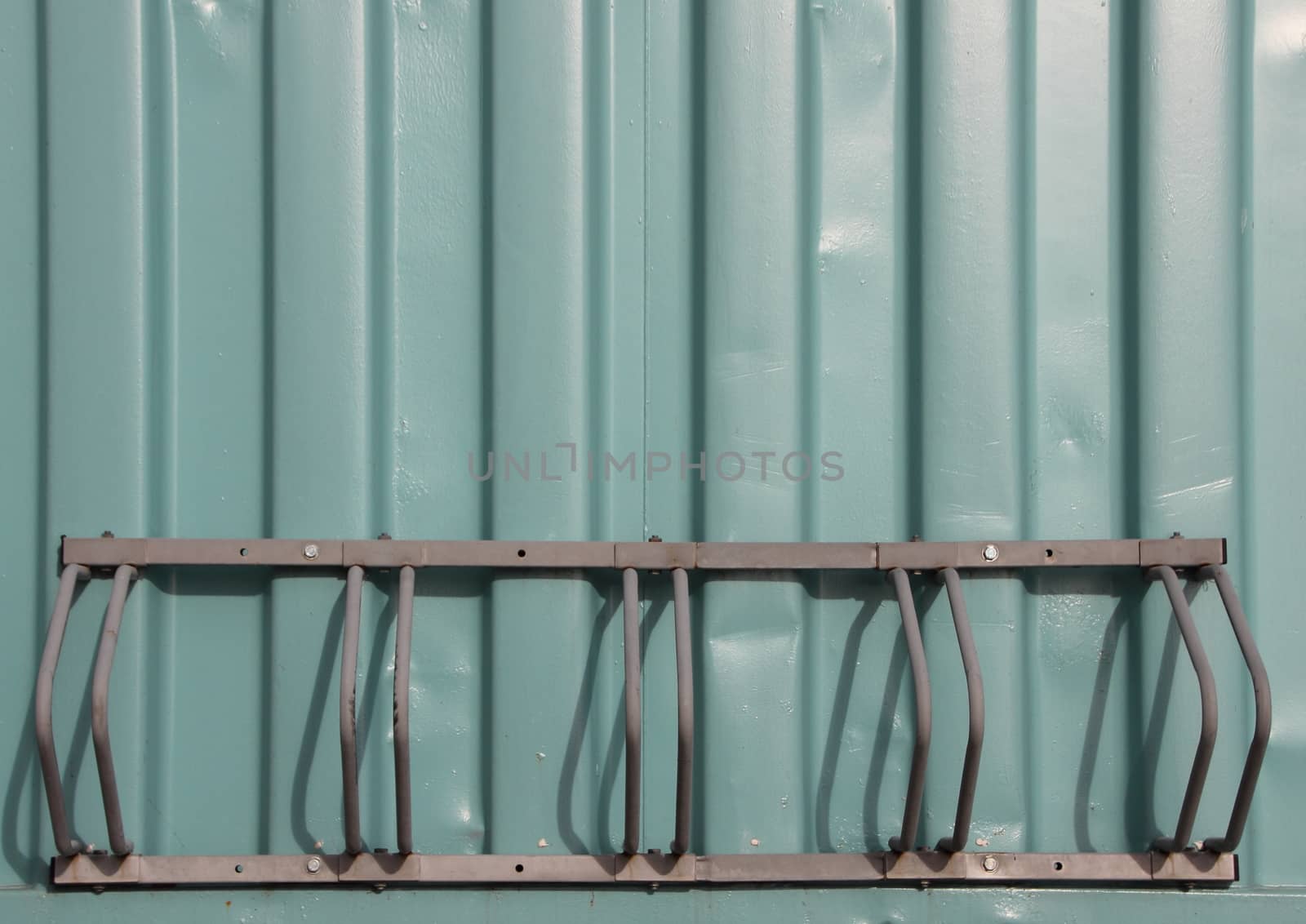 Empty Metal Bicycle Parking Rack Mount on Green Container