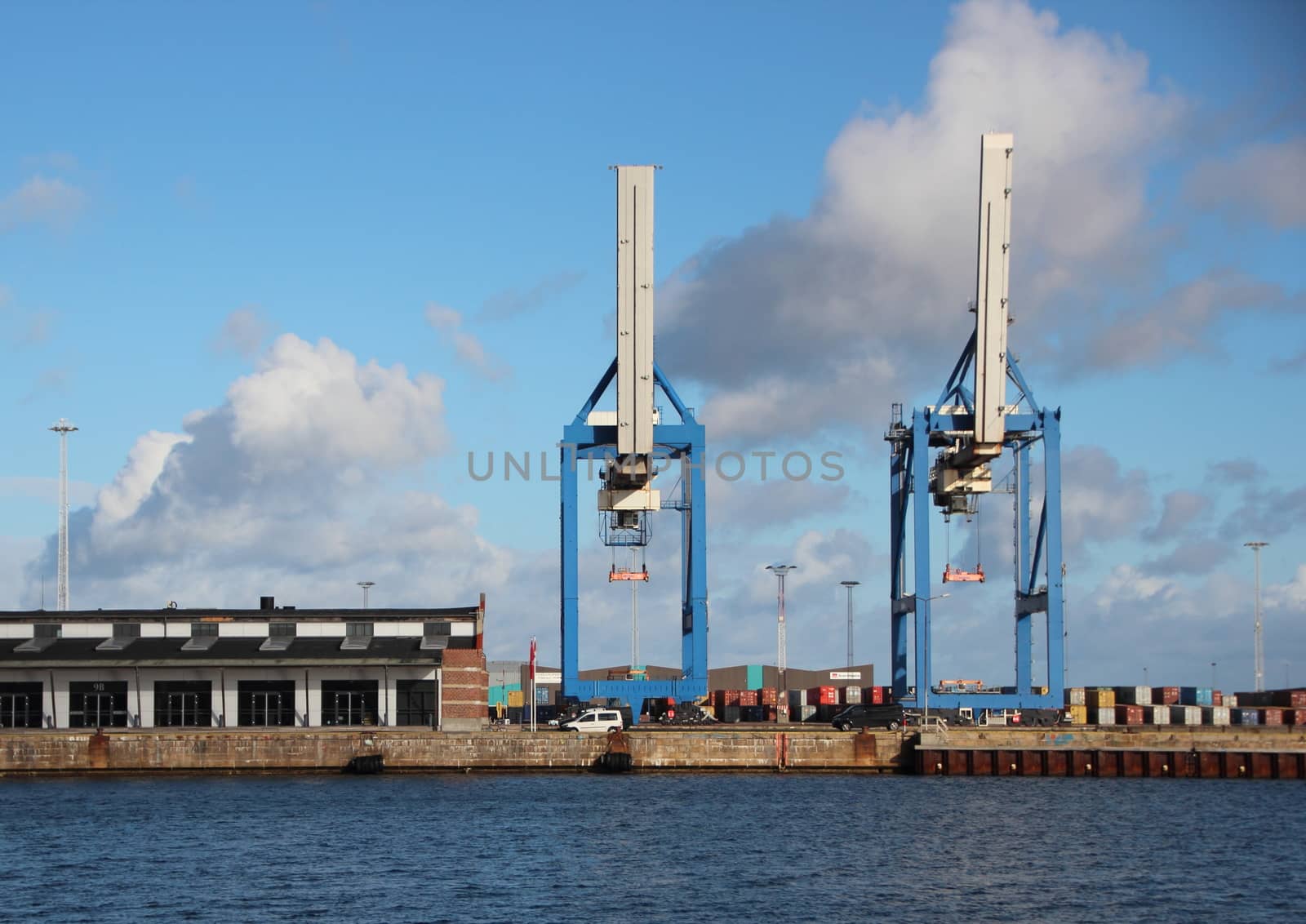 Container Industrial Cranes at Harbor Pier with Blue Water Front