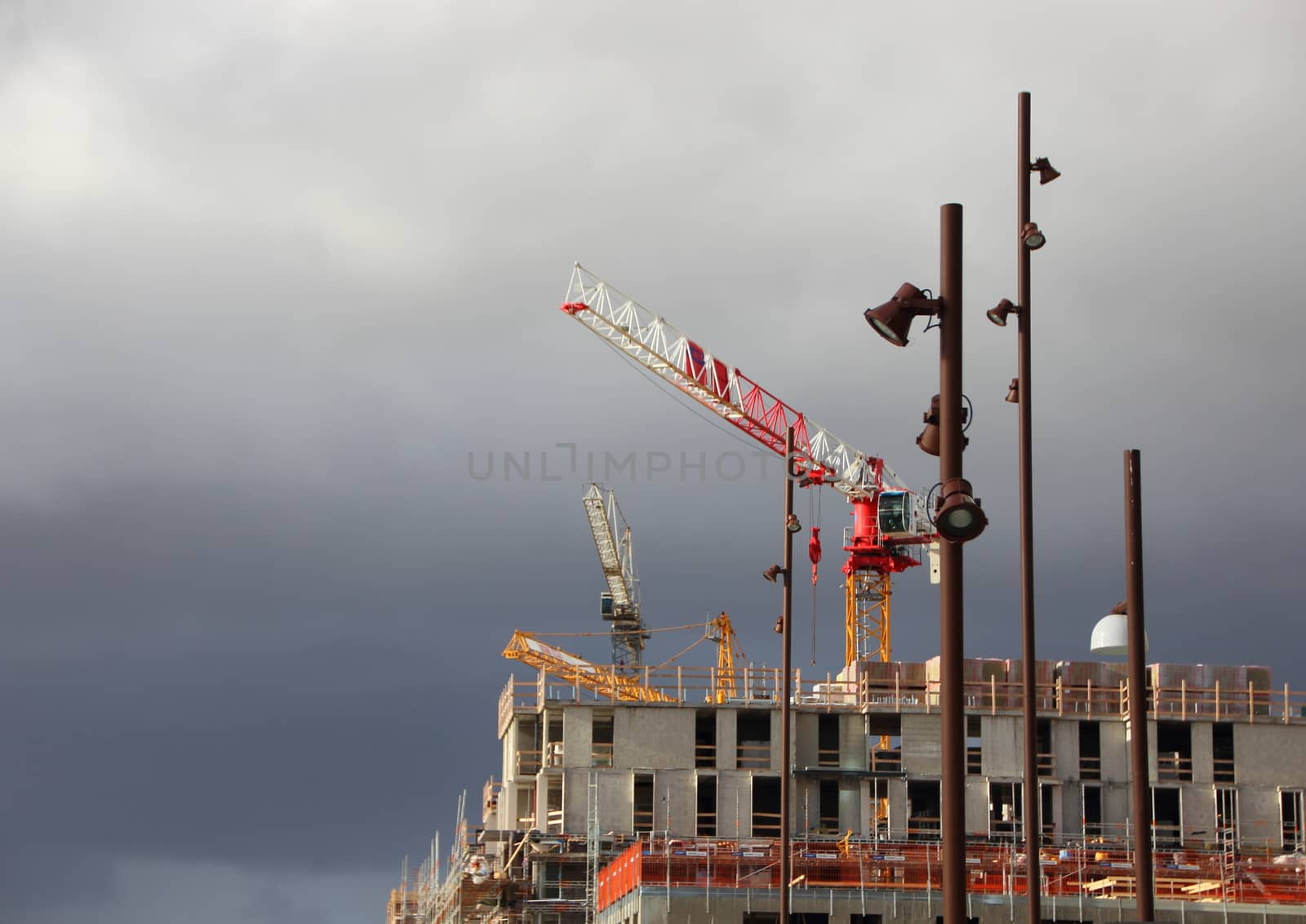 Building Site Cranes and Street Lamps with Dark Clouds
