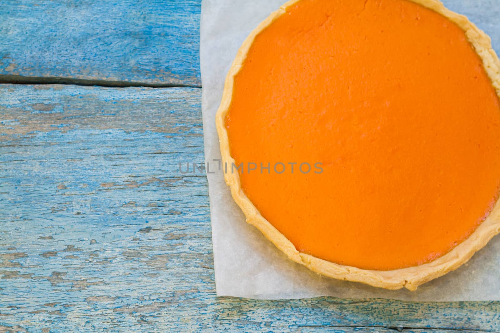 Bright pumpkin tart, flan, in the context of cream.