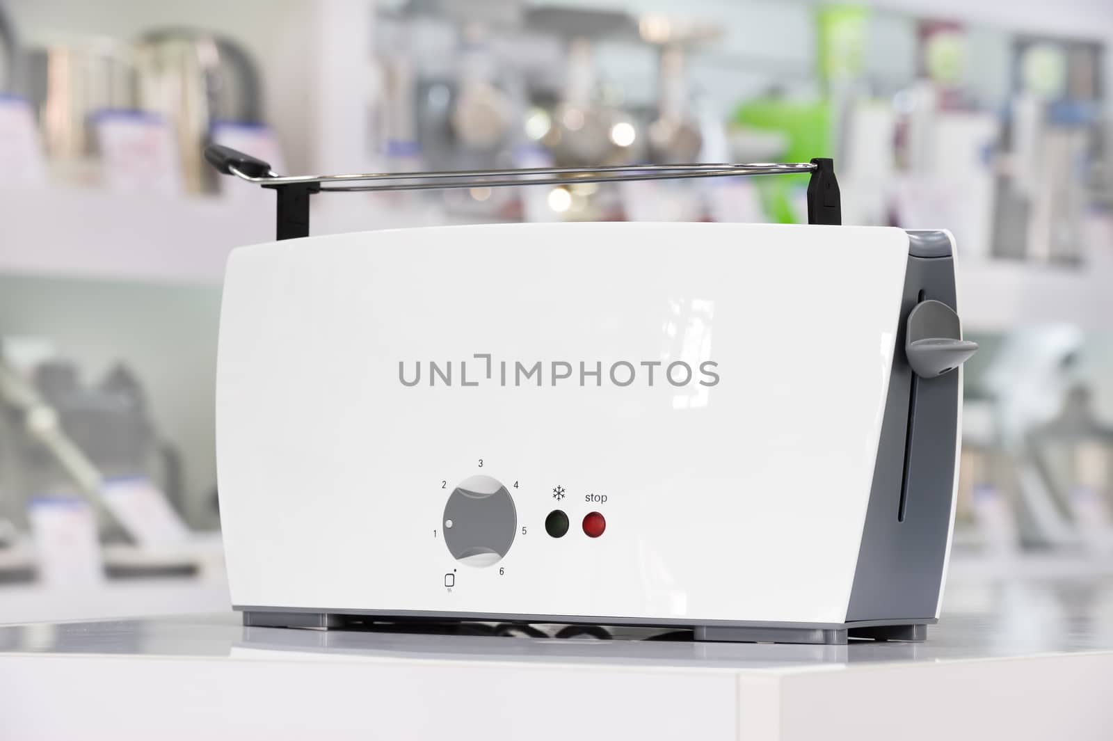 Single brand new white plastic shiny toaster at retail store shelf, defocused background