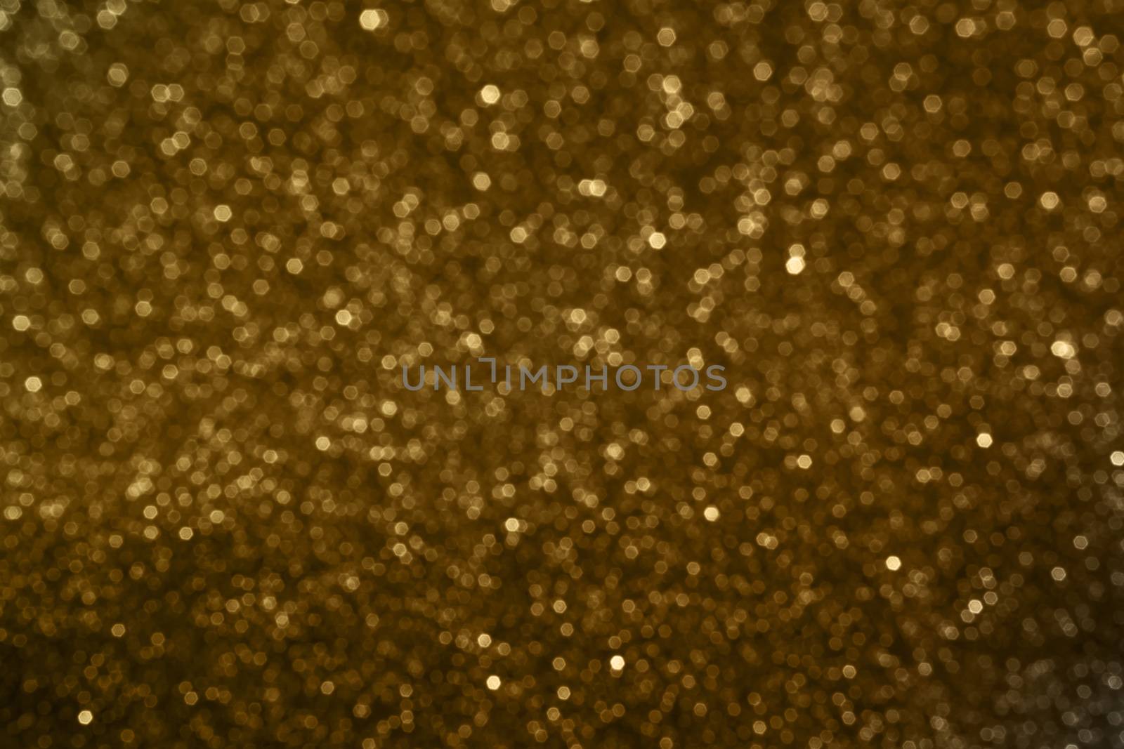 Small bokeh light sparkle shining on golden dark background