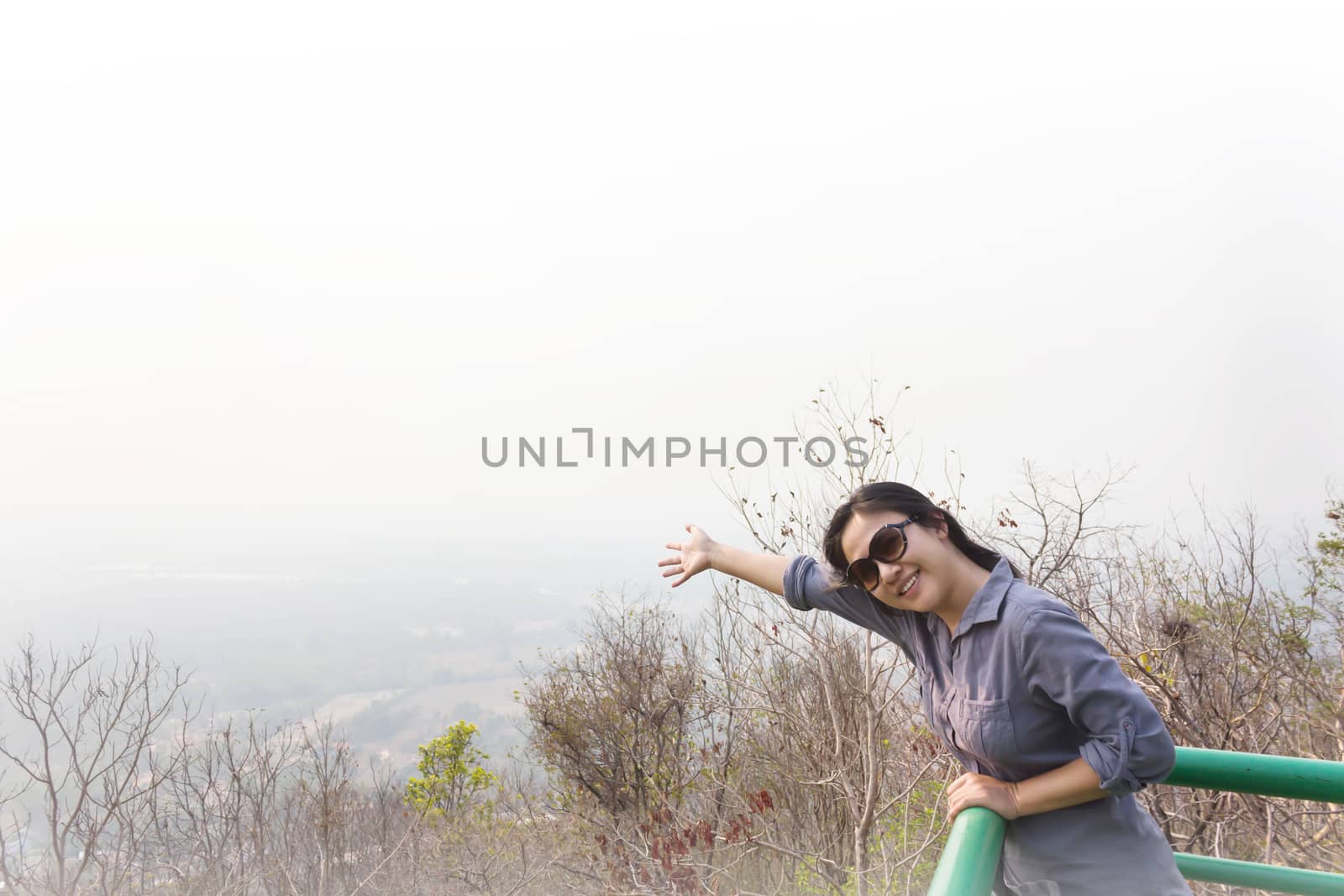 Asian lady smiling and relax on highland top view seeing point with nature background