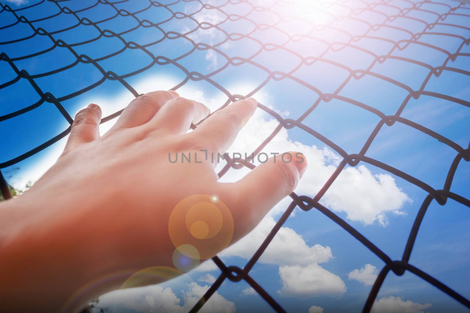 Lady or girl hand catching iron bar with sky and clouds background, freedom desire feeling