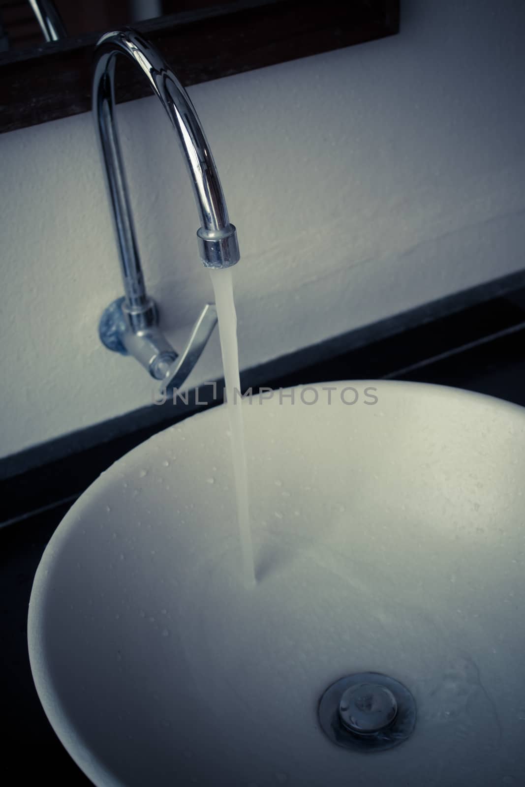 Water tap over white ceramic washbasin by worrayuth