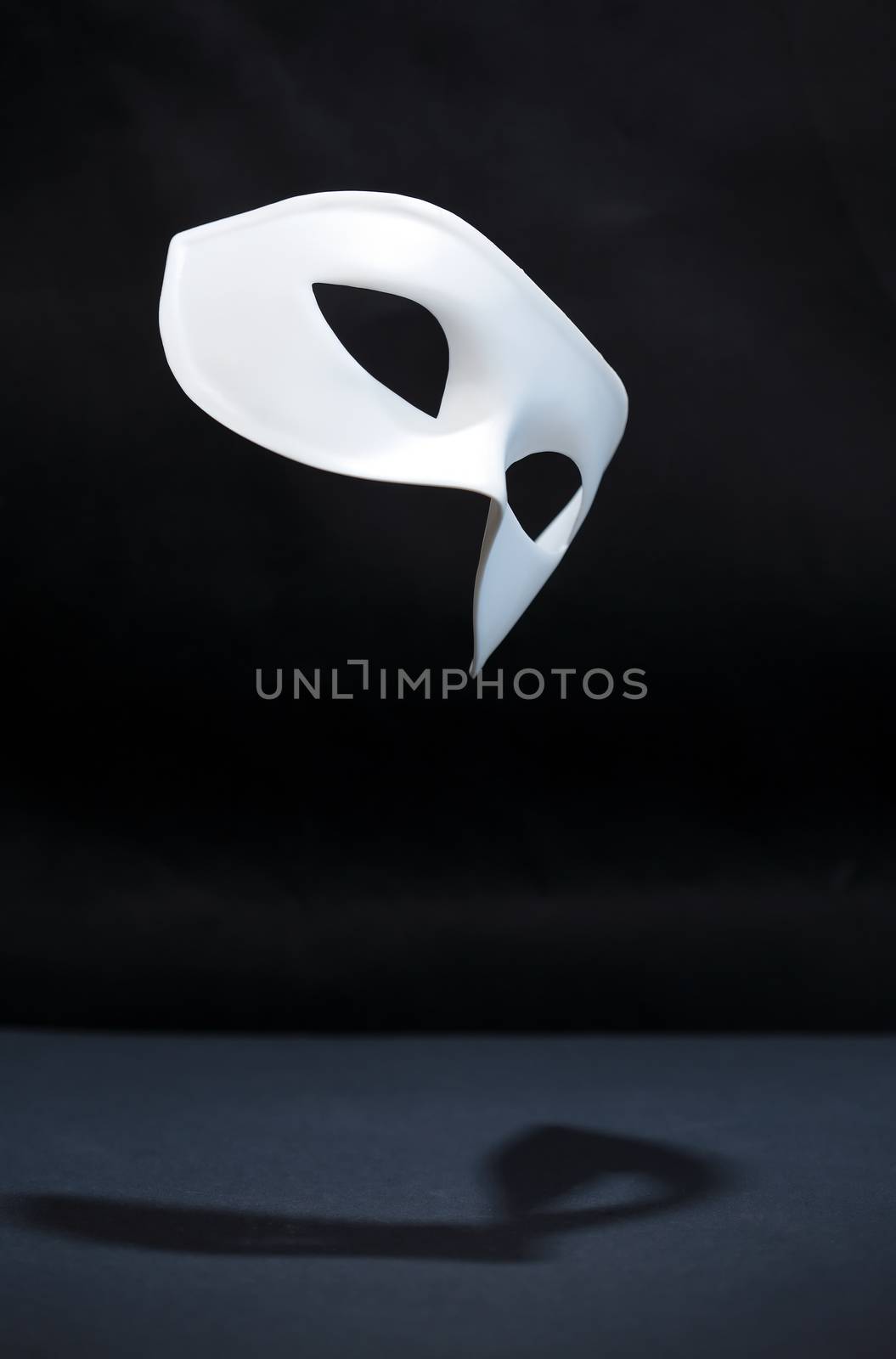 Freedom concept. Closeup of white classical carnival mask on dark