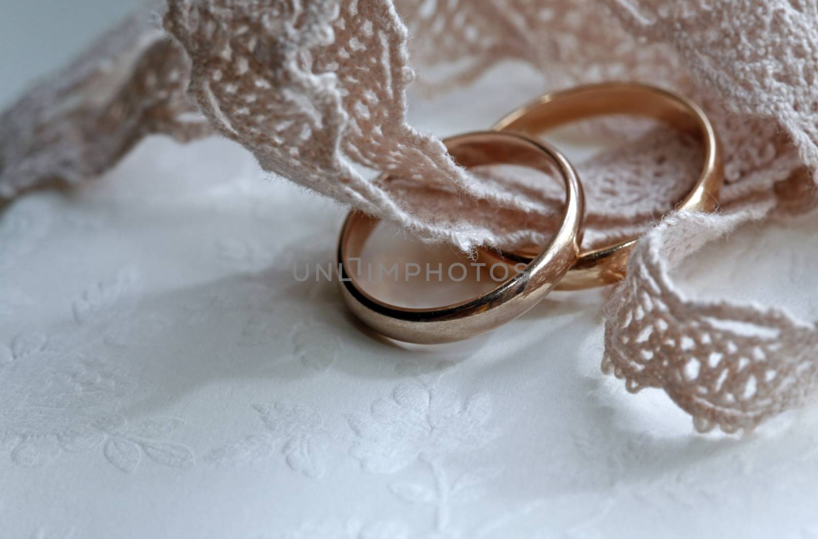 Wedding rings on a pink tape close-up
