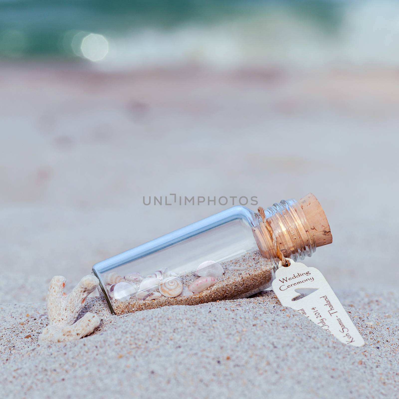 Close up bottle of Wedding invitation  with sea shell and paper  by kerdkanno