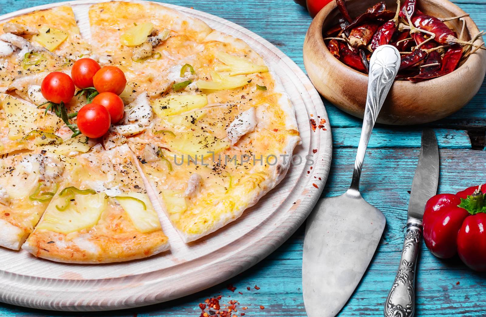 Meat delicious pizza with cherry tomatoes on wooden tray and hot spices