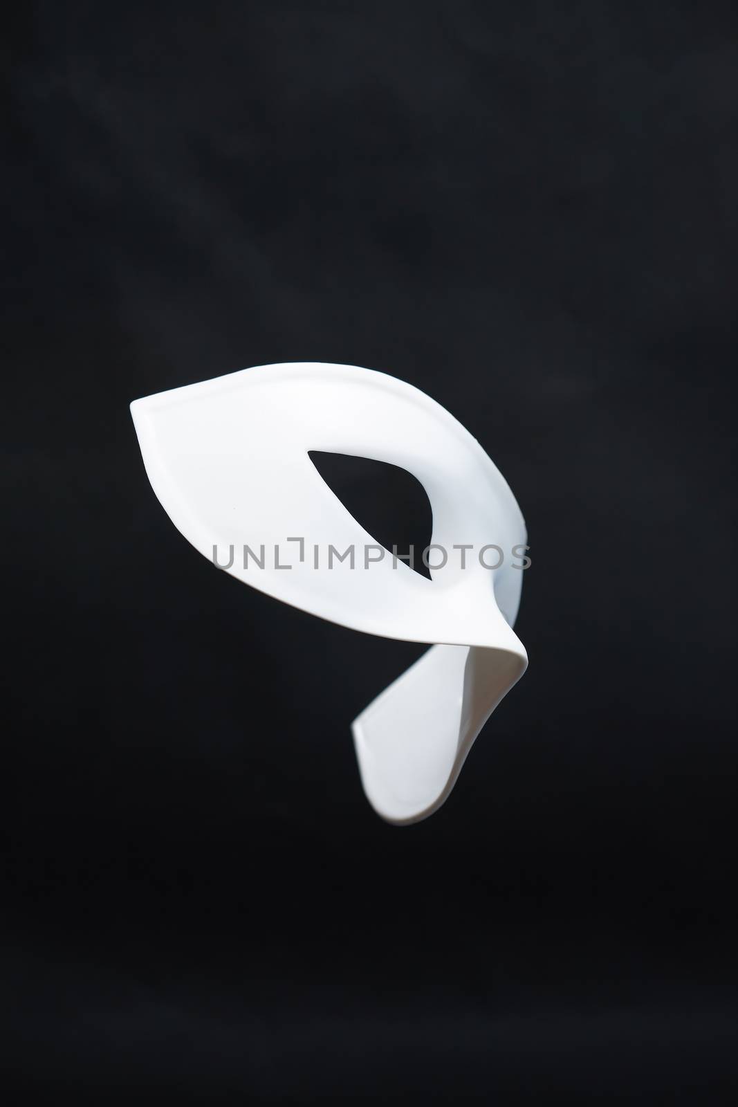 Theater concept. Closeup of white classical carnival mask on dark