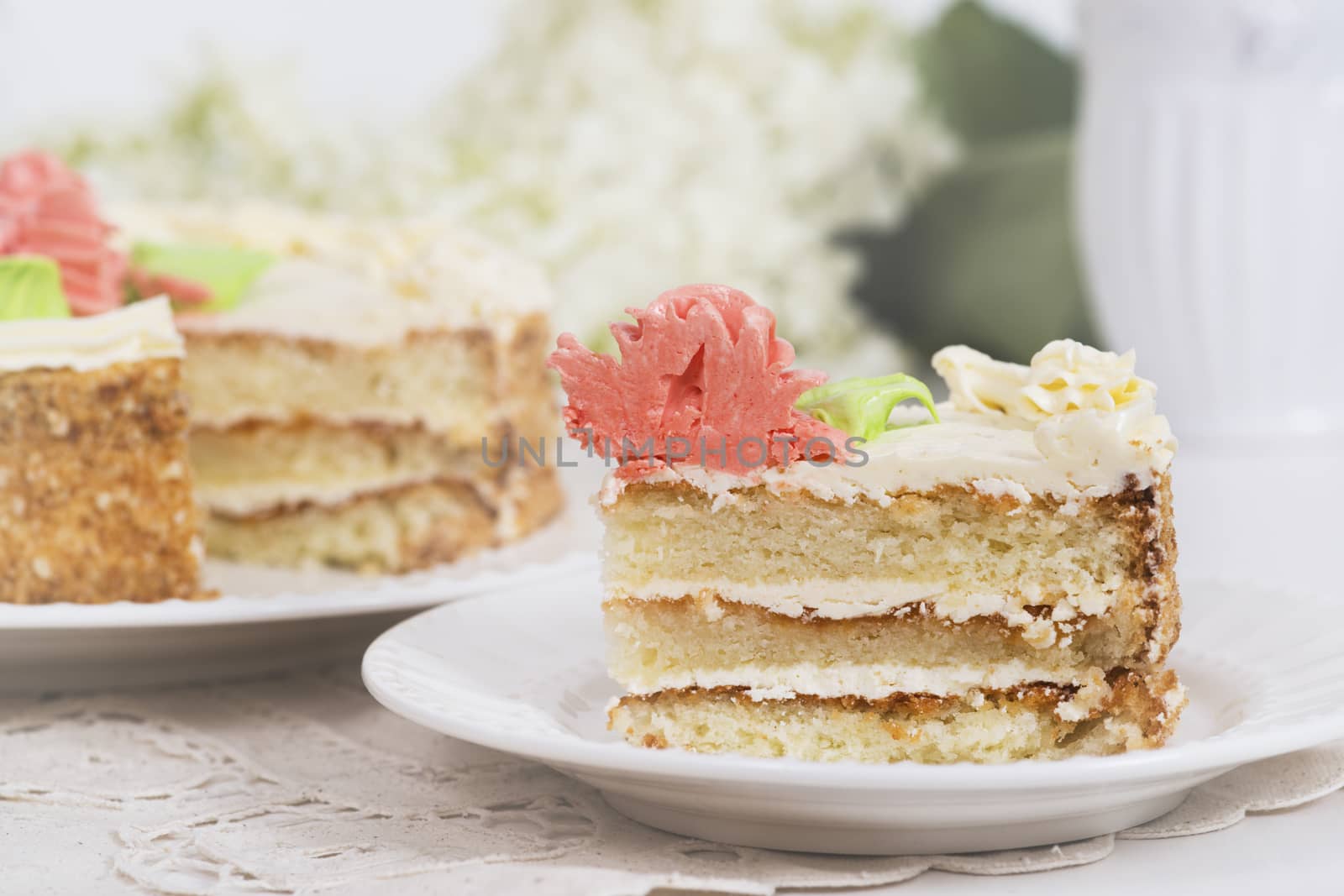 Creamy cake on plate on table on light background, selective focus.