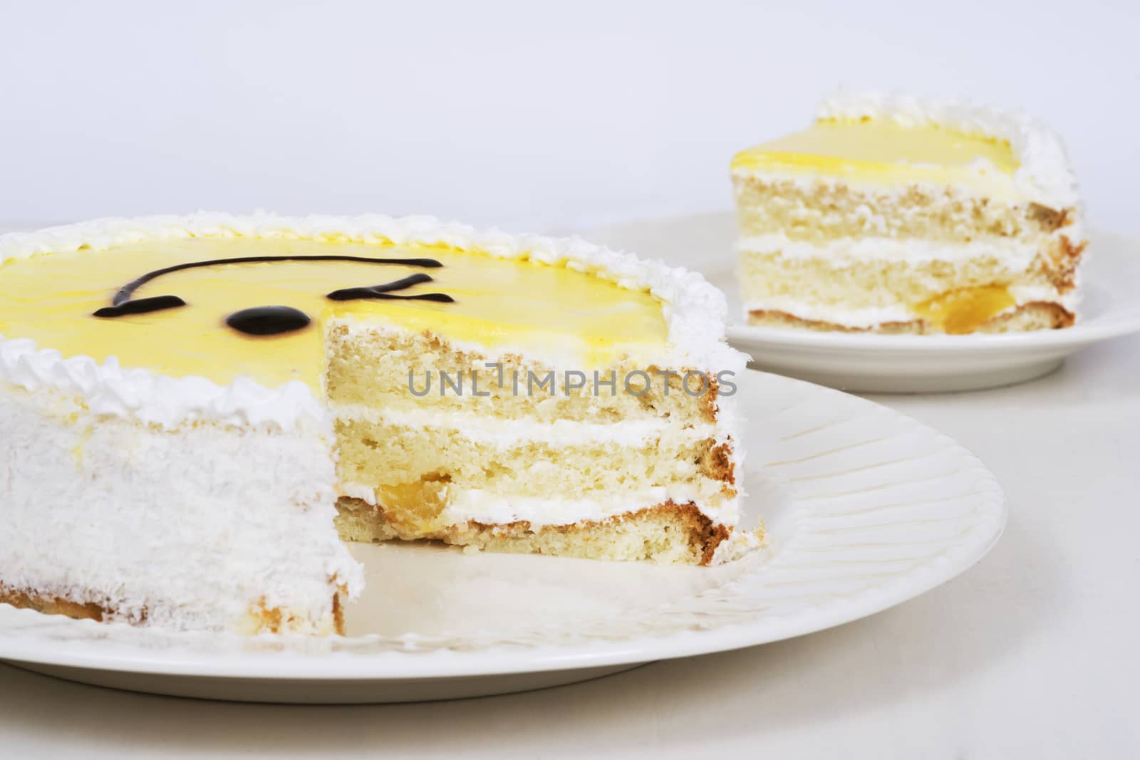 Yellow cake on plate on table on light background