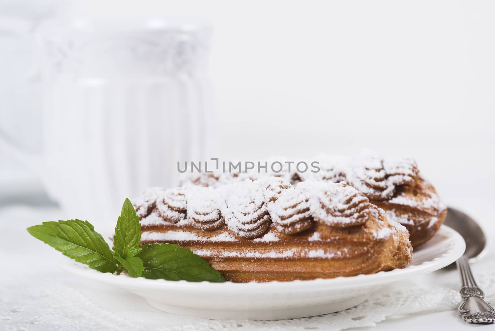 Eclairs on plate on a table on light background