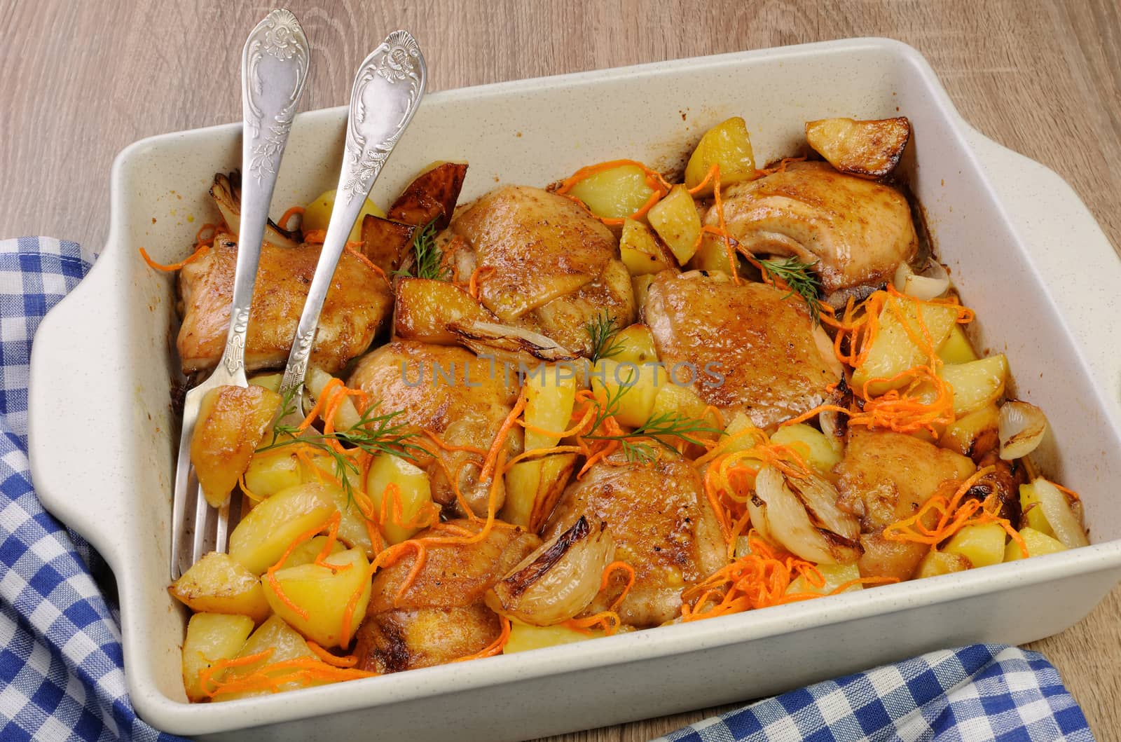 Braised roast chicken and vegetables in ceramic roasting pan